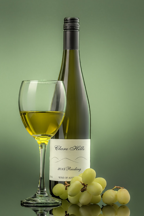 White Wine with glass of wine and grapes on green background