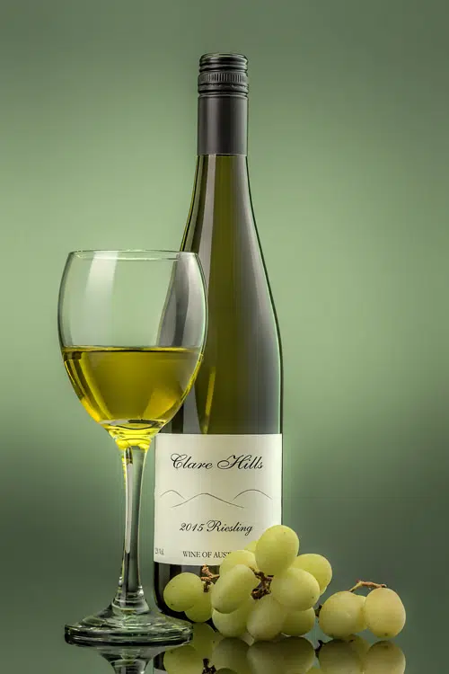 White Wine with glass of wine and grapes on green background