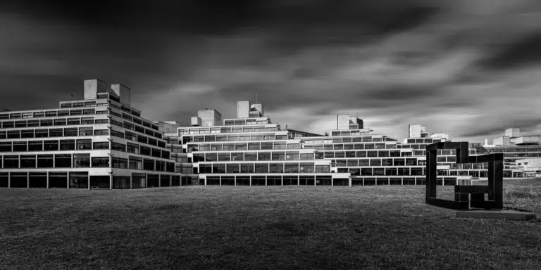 UEA Ziggurats monochrome long exposure with sculpture in foreground