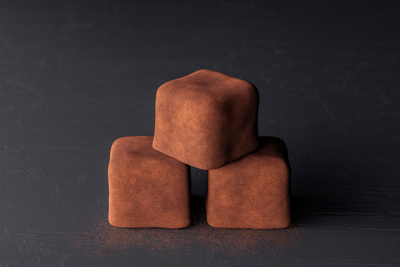 Dusted chocolate truffle squares on slate CGI