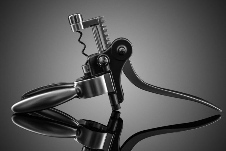 Monochrome product photo of a mechanical corkscrew opened up
