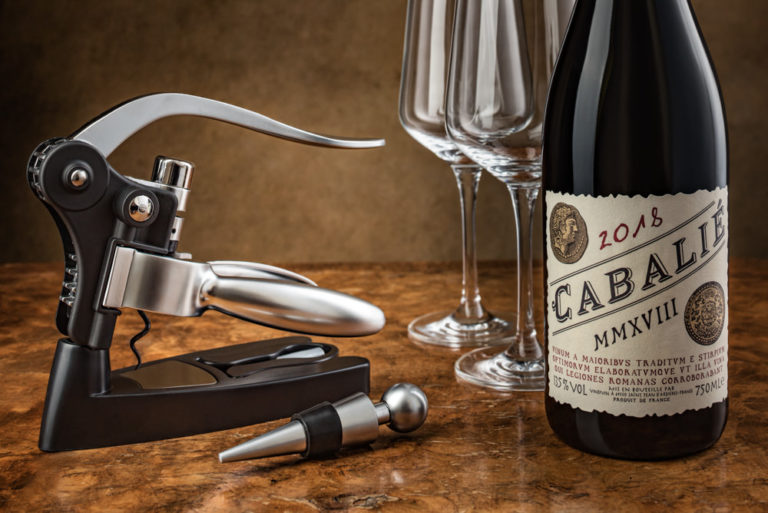 Lifestyle product image of a corkscrew with a bottle of red wine and 2 empty glasses