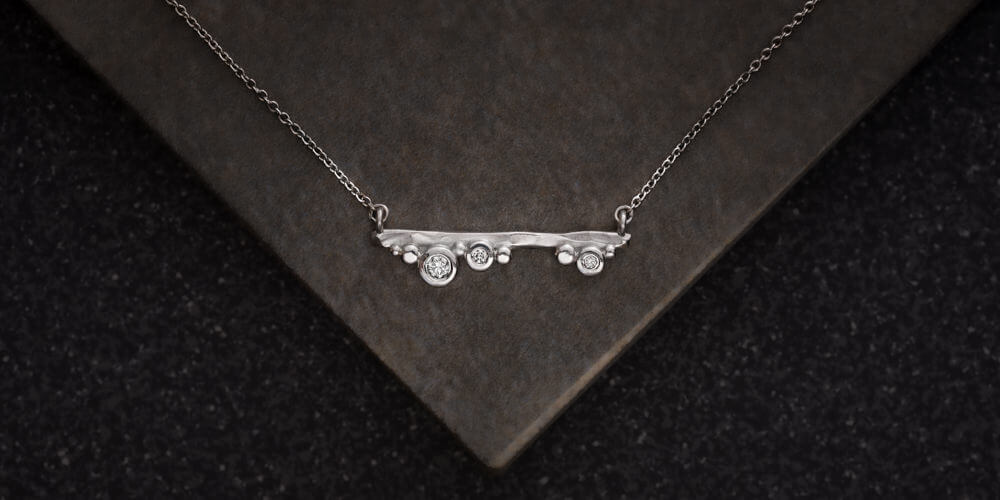 Diamond & Silver necklace Jewelery photography sample on tile background